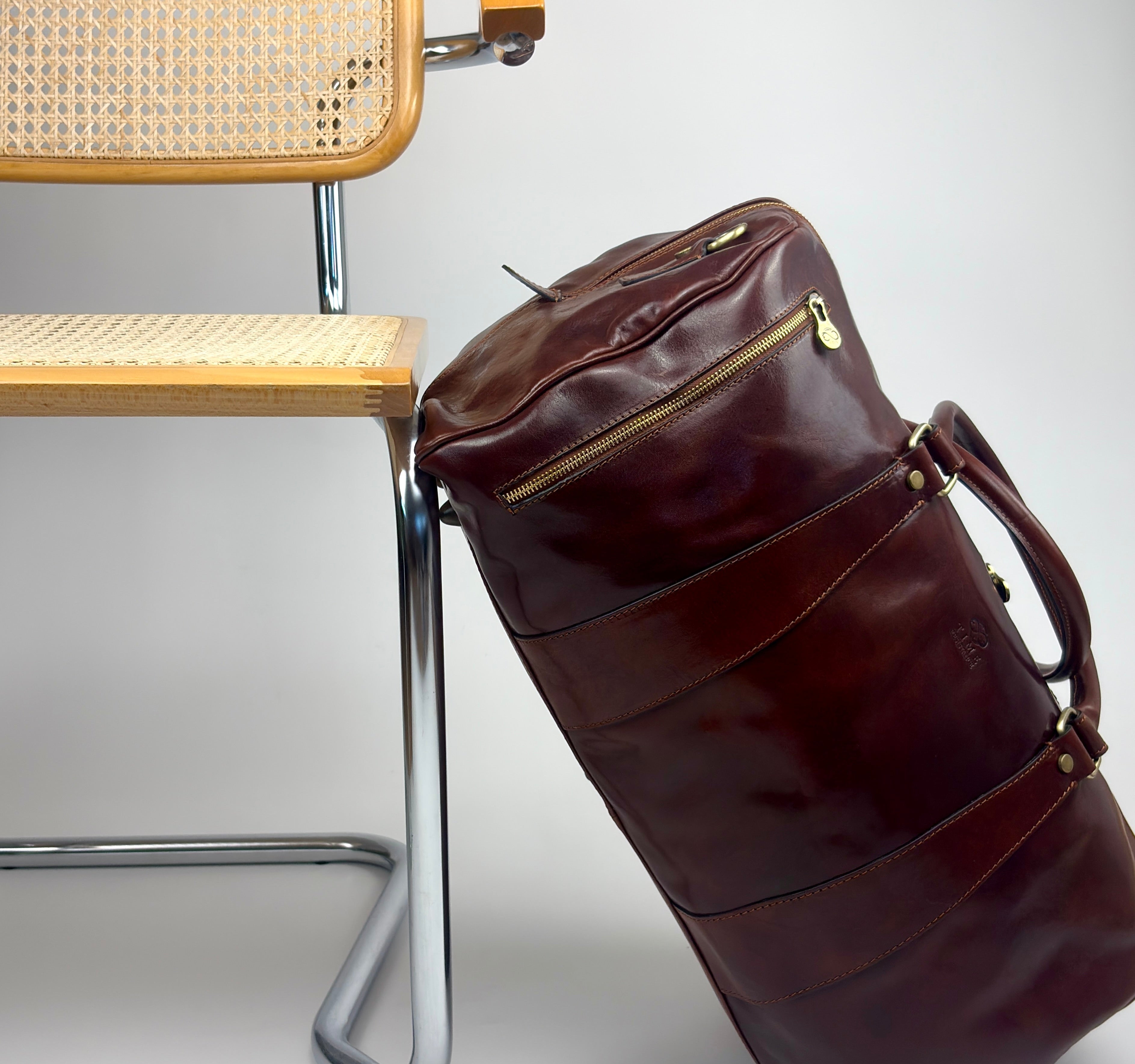 Time Resistance Reisetasche Leder lehnt an Freischwinger-Stuhl